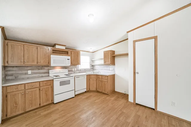 a kitchen with a sink cabinets and wooden floor