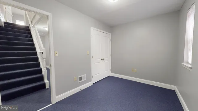 an empty room with stairs and white walls