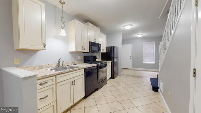 a kitchen with a sink a stove a refrigerator and cabinets