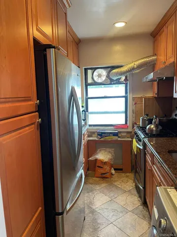 a view of kitchen with window and refrigerator