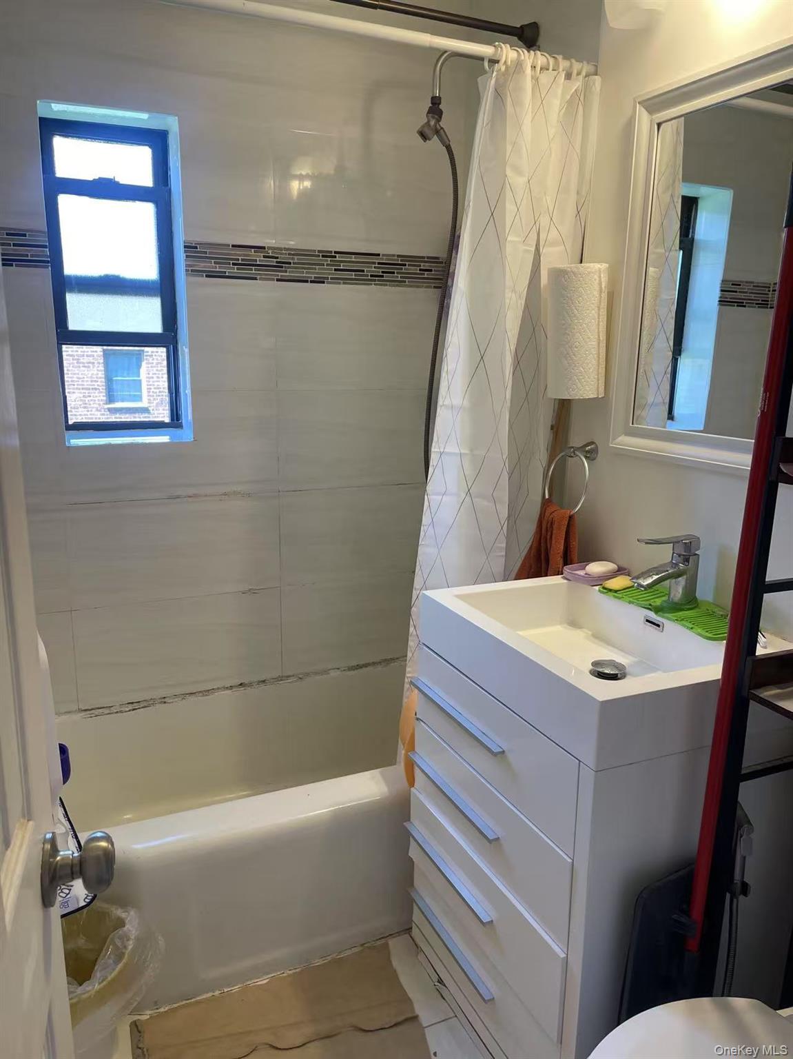 67-12 197th Street, Unit 1 Queens, NY 11365 - Photo 2 of 5 a bathroom with a granite countertop sink toilet and shower