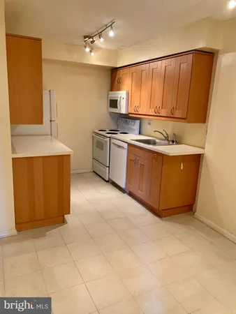 a kitchen with stainless steel appliances a sink a stove top oven a refrigerator and island