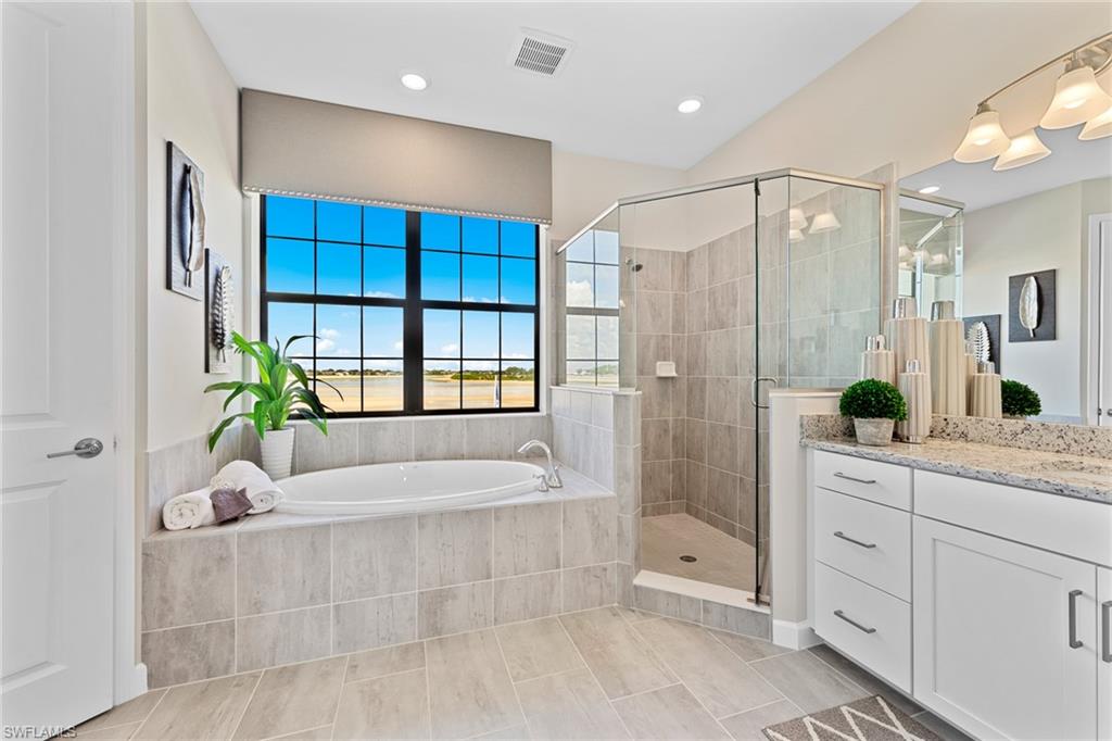 14351 Lagoon Lane Babcock Ranch, FL 33982 - Photo 21 of 39 a spacious bathroom with a granite countertop tub shower and mirror
