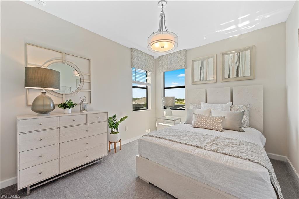 14351 Lagoon Lane Babcock Ranch, FL 33982 - Photo 26 of 39 a bedroom with a large bed and a chandelier