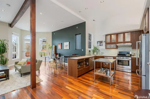 a living room with stainless steel appliances kitchen island granite countertop wooden floor a dining table and chairs with wooden floor
