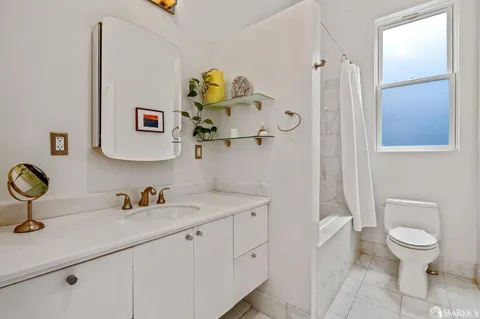 a bathroom with a toilet sink and mirror