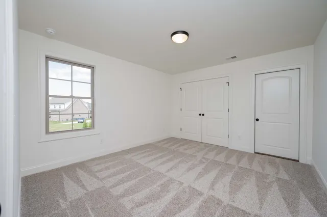 an empty room with closet and windows