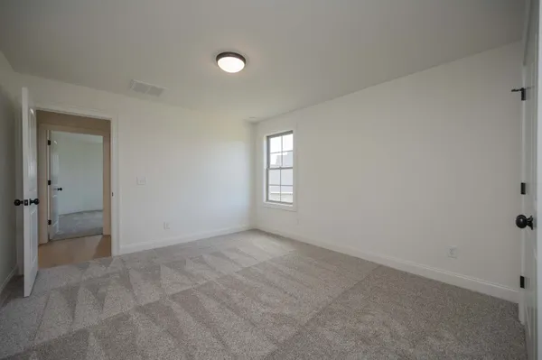 an empty room with a fireplace and windows