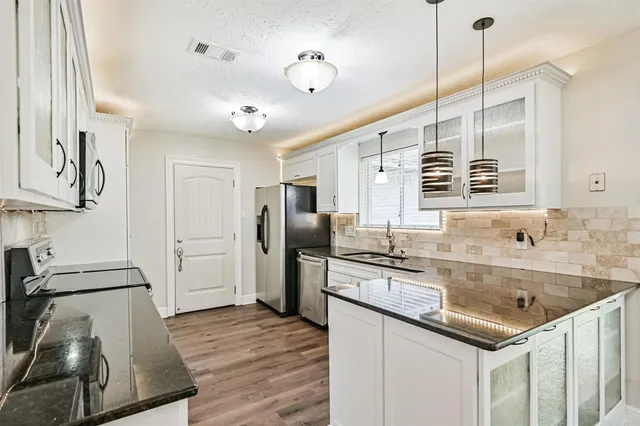 a kitchen with stainless steel appliances granite countertop a sink stove and refrigerator