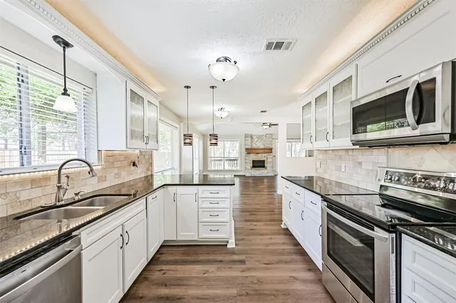 a large kitchen with stainless steel appliances granite countertop a sink and stove top oven