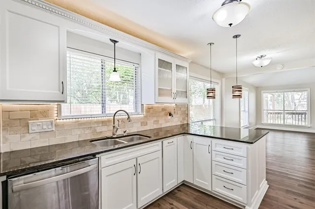 a kitchen with cabinets appliances and a large window