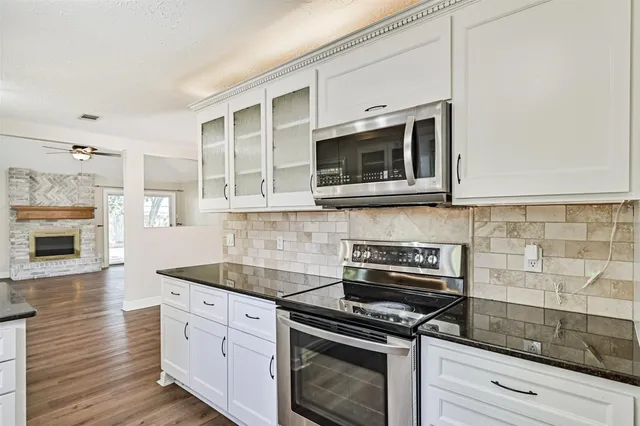a kitchen with stainless steel appliances granite countertop a stove microwave and cabinets