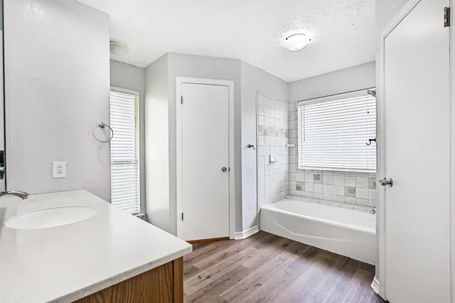 a bathroom with a tub sink and mirror