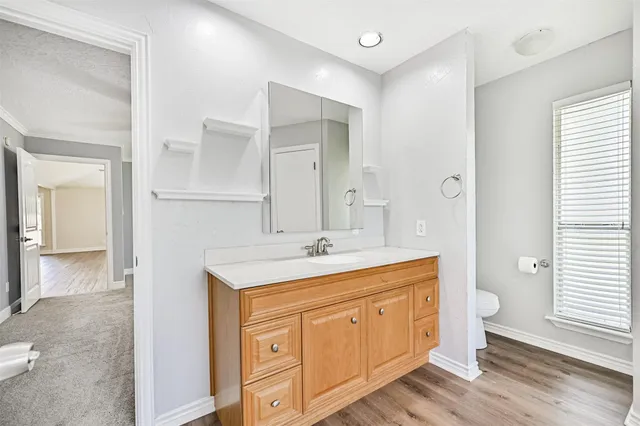 a bathroom with a granite countertop sink toilet a large mirror and shower