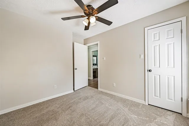 an empty room with closet and a ceiling fan
