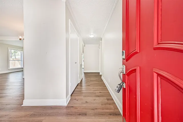 a view of a hallway with wooden floor and staircase