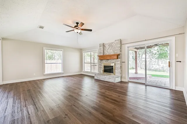 a view of empty room with wooden floor and fireplace