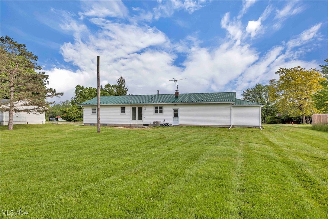 7843 Stone Road Medina, OH 44256 - Photo 4 of 27 Back of property with a lawn, metal roof, and a chimney