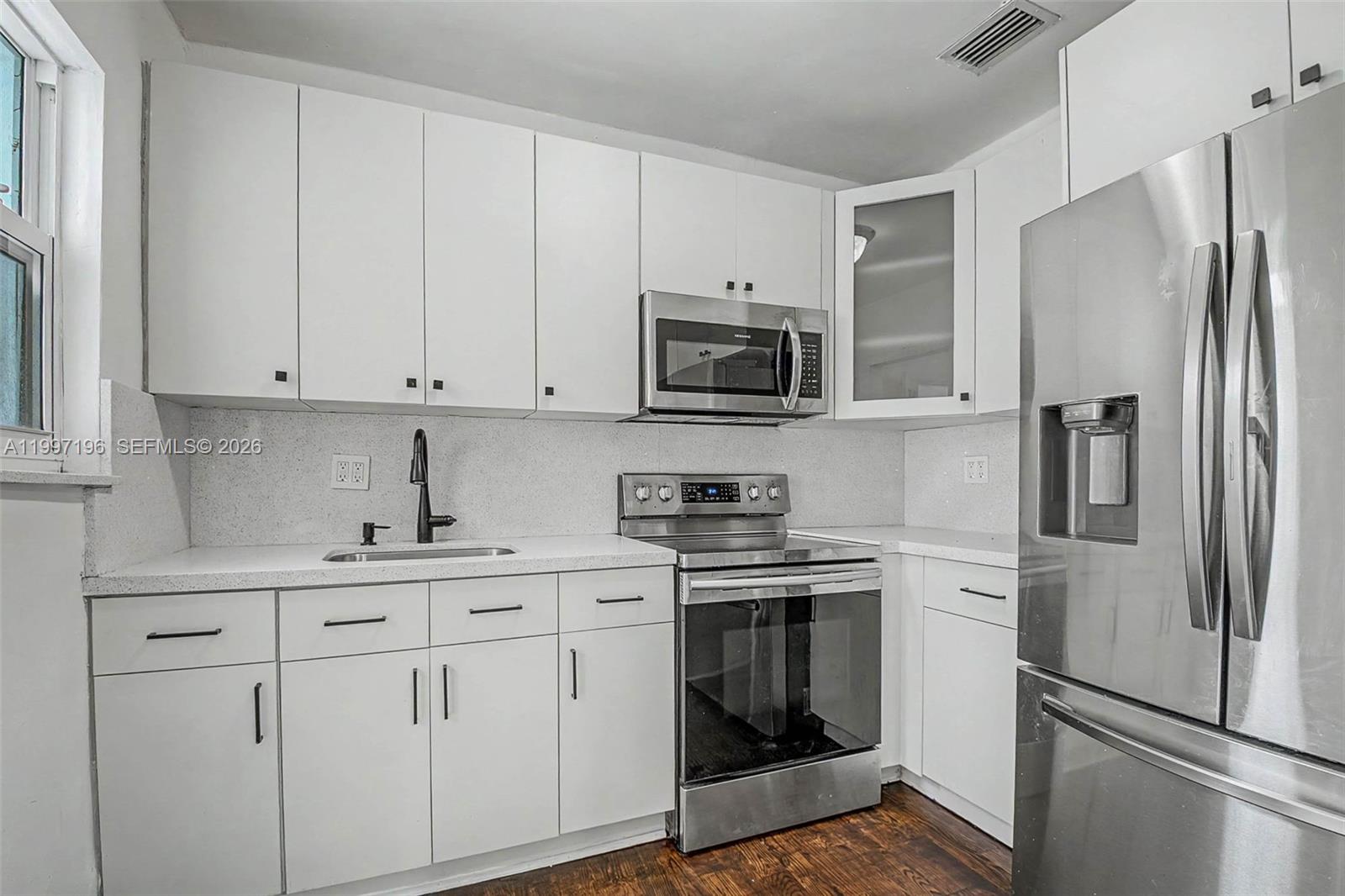 3951 Southwest 2nd Terrace Miami, FL 33134 - Photo 5 of 32 a kitchen with white cabinets stainless steel appliances and a sink