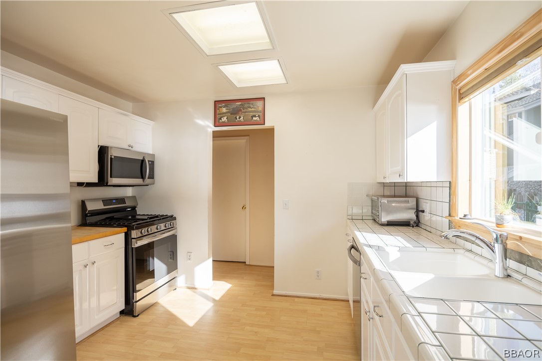 136 Round Drive Big Bear Lake, CA 92315 - Photo 14 of 45 a kitchen with granite countertop a sink and a stove top oven