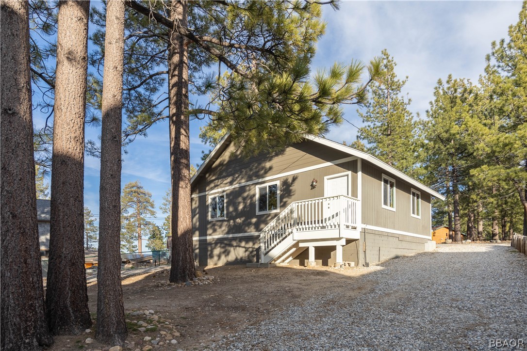 136 Round Drive Big Bear Lake, CA 92315 - Photo 37 of 45 a view of a white house with a large tree and a yard