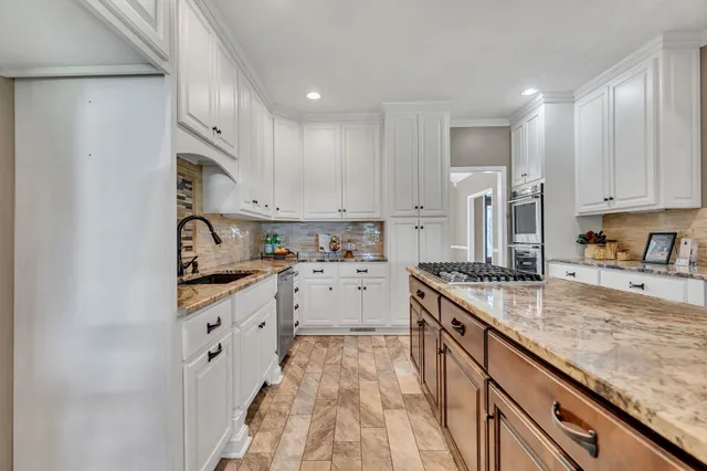 a kitchen with granite countertop white cabinets and white appliances