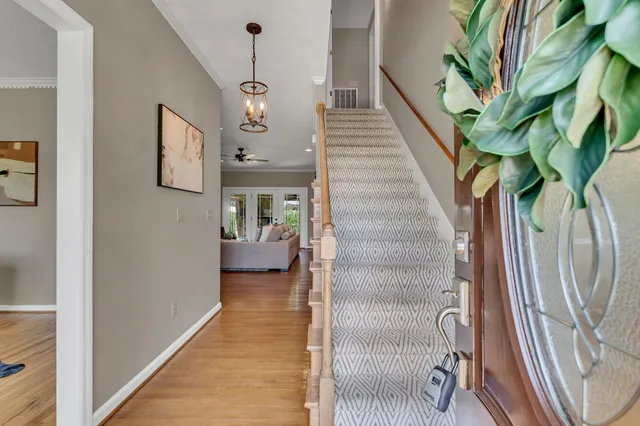a view of a hallway with wooden floor and stairs