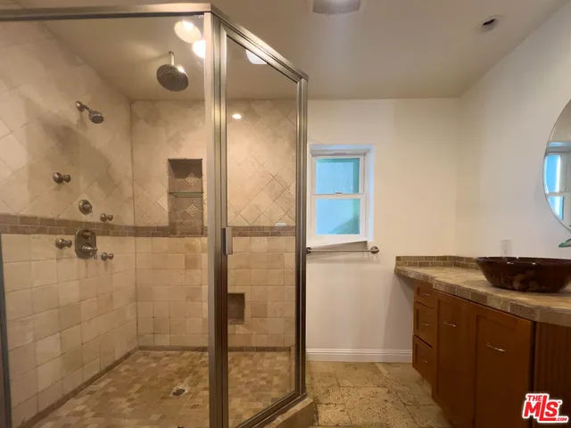 a bathroom with a granite countertop shower mirror and a sink