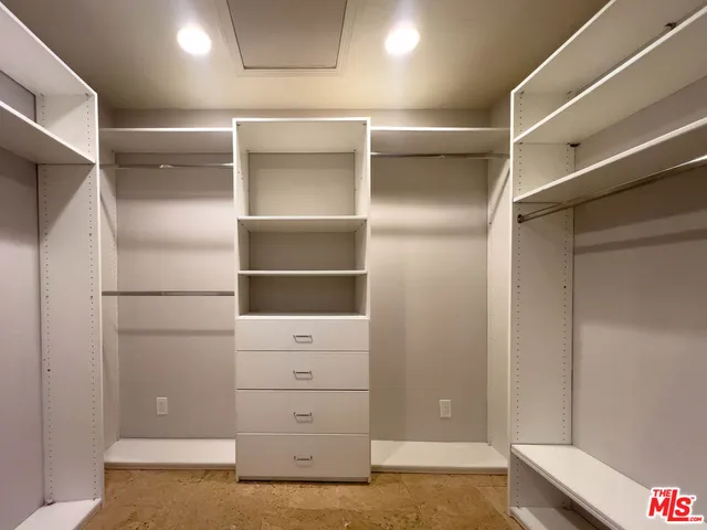 a view of walk in closet with empty racks