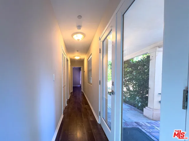 a view of a hallway with wooden floor and entryway