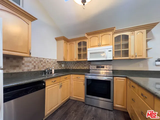 a kitchen with stainless steel appliances granite countertop a stove and a sink