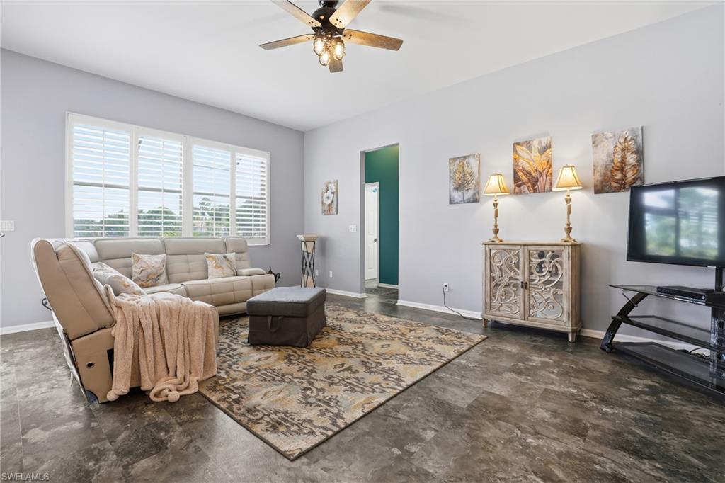 3236 Potomac Court Naples, FL 34120 - Photo 12 of 47 a living room with furniture a chandelier and a window