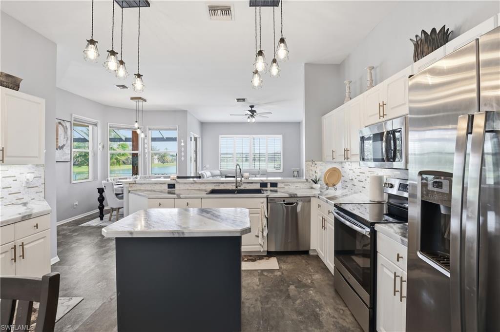 3236 Potomac Court Naples, FL 34120 - Photo 16 of 47 a kitchen with stainless steel appliances granite countertop a sink stove and refrigerator