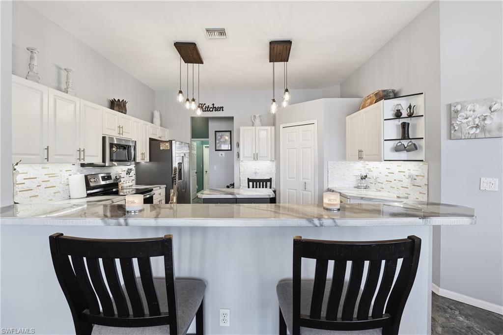 3236 Potomac Court Naples, FL 34120 - Photo 19 of 47 a kitchen with stainless steel appliances granite countertop a sink dishwasher a stove and a refrigerator with wooden floor