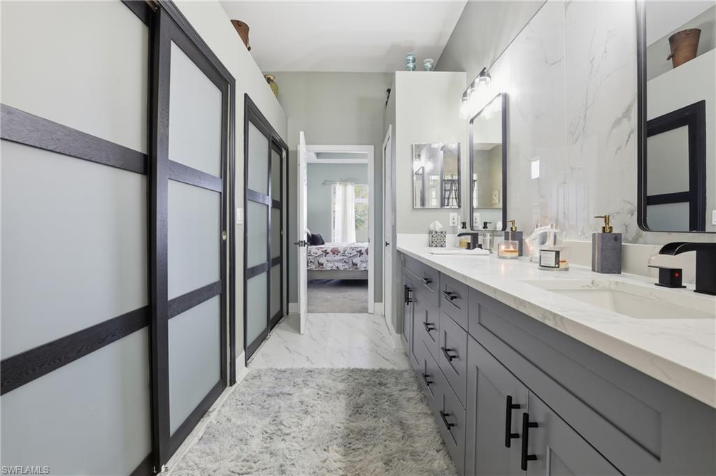 3236 Potomac Court Naples, FL 34120 - Photo 24 of 47 a spacious bathroom with a double vanity sink a mirror and a shower