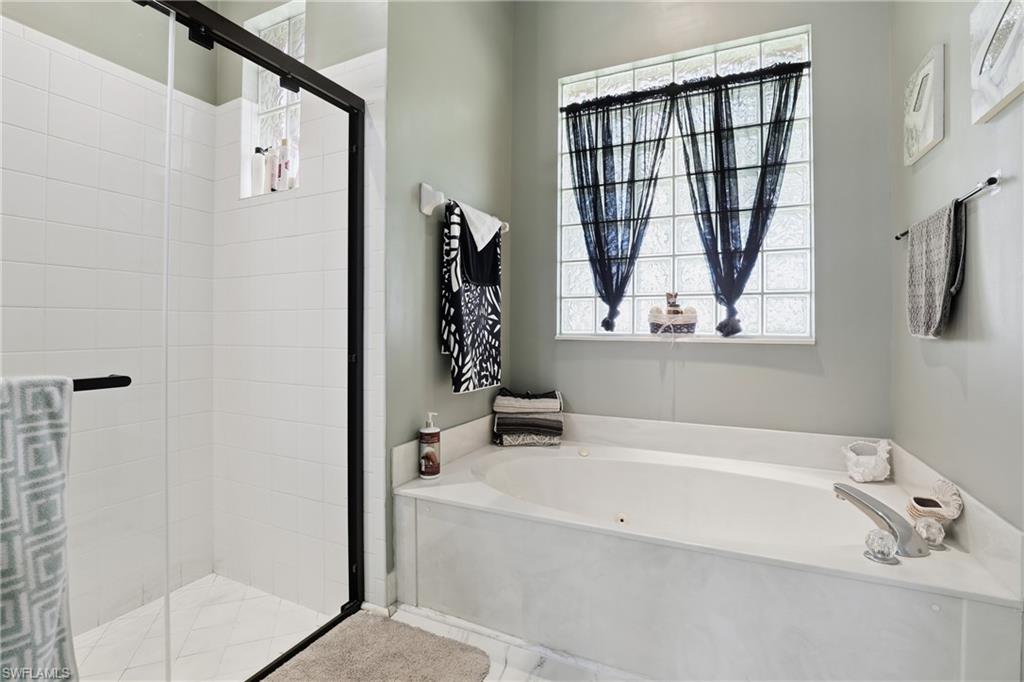 3236 Potomac Court Naples, FL 34120 - Photo 25 of 47 a bathroom with a tub a sink and a window