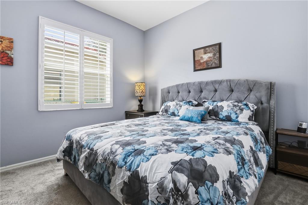 3236 Potomac Court Naples, FL 34120 - Photo 26 of 47 a large bed sitting in a bedroom next to a window