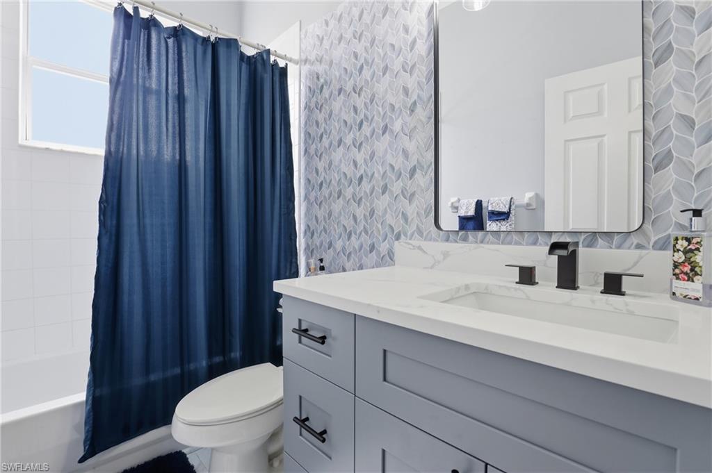 3236 Potomac Court Naples, FL 34120 - Photo 34 of 47 a bathroom with a sink a toilet a mirror and shower curtain