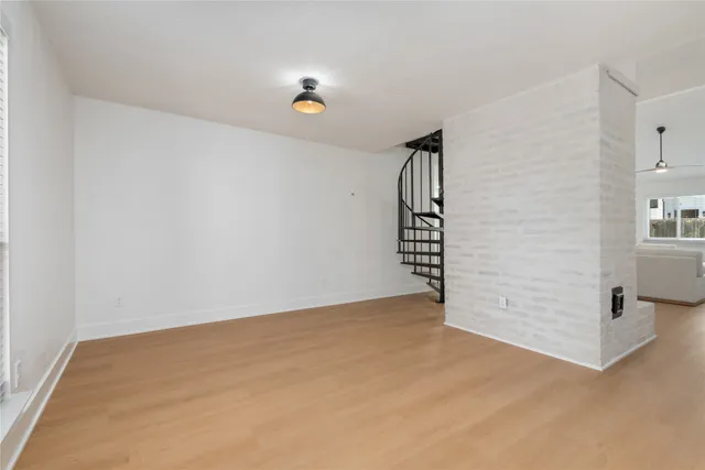 a view of a hallway with wooden floor and staircase
