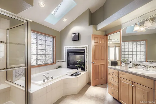 a spacious bathroom with a tub sink shower and mirror
