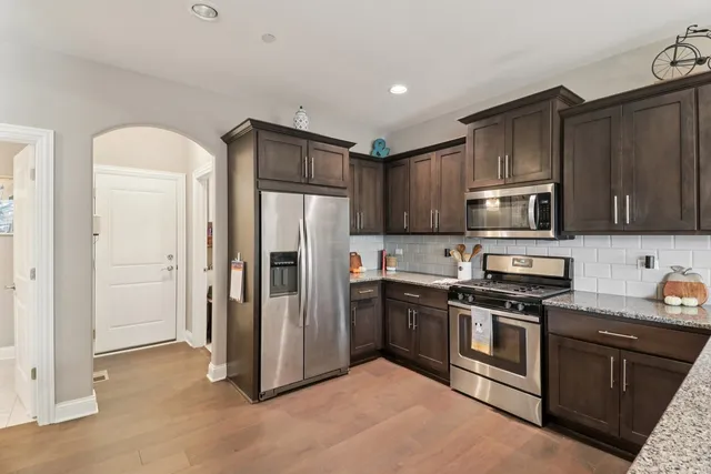 a kitchen with stainless steel appliances granite countertop a refrigerator stove and microwave