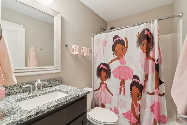 a bathroom with a granite countertop toilet sink and a mirror