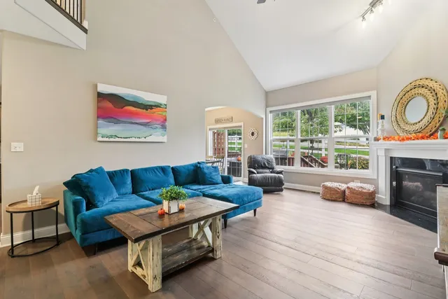 a living room with furniture a fireplace and a large window