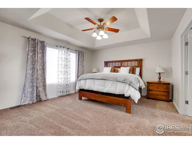 a bed room with a bed and a ceiling fan
