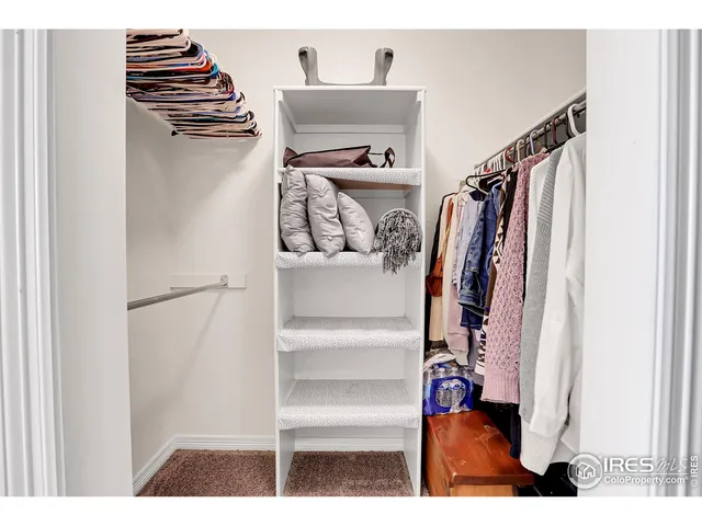 a view of walk in closet with clothes and shoes