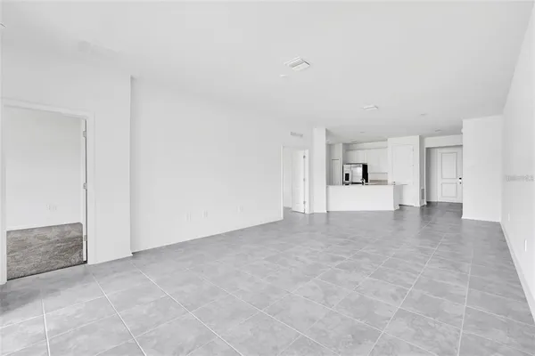 a view of empty room with kitchen