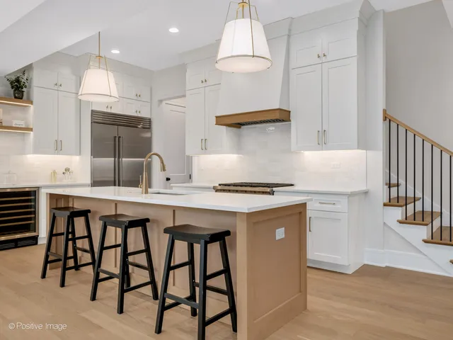 a kitchen with granite countertop a table chairs stove a refrigerator and microwave