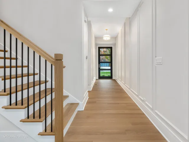 a view of a hallway with wooden floor and entryway
