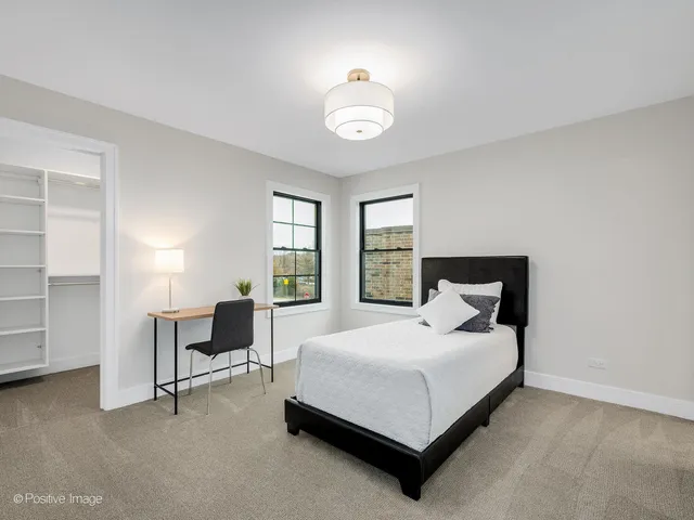 a bedroom with a bed a table and chair