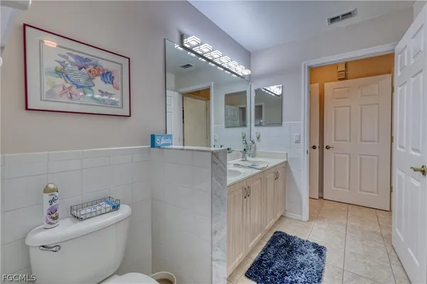 a bathroom with a double vanity sink mirror and toilet